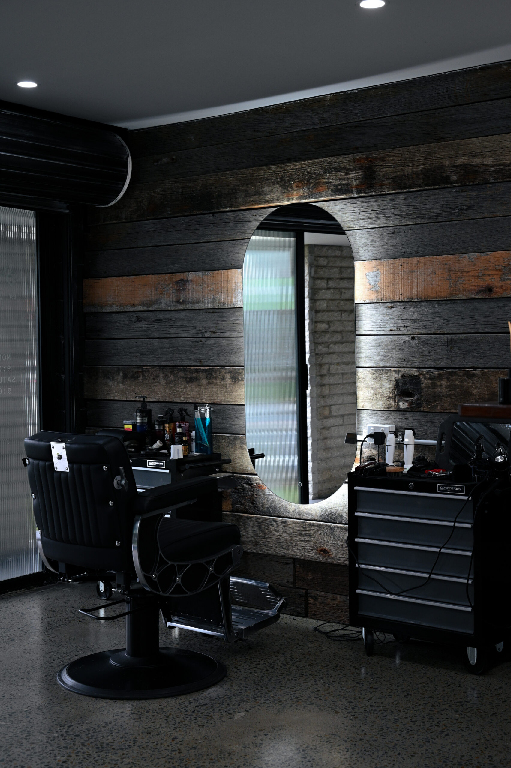 A Blacksmith barber chair against reclaimed timber